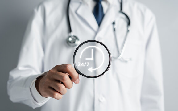 Doctor in a white coat uniform holding 24/7 service icon for assistance patient when accident or emergency, Medical call center service without interruption day and night.