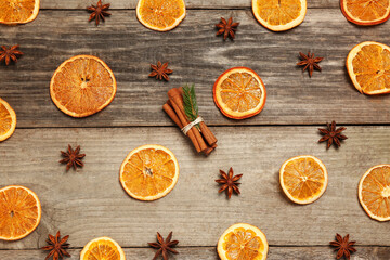 Flat lay composition with dry orange slices, anise stars and cinnamon sticks on wooden table