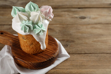 Traditional Easter cake decorated with meringues on wooden table, space for text