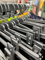 Close-up of various trouser hanger holders on display in a specialty store, symbolizing the textile trade