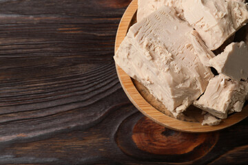 Compressed yeast on wooden table, top view. Space for text