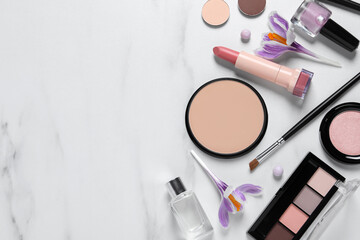 Flat lay composition with different makeup products and beautiful crocuses on white marble table, space for text
