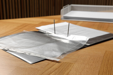 File folder with punched pockets on wooden table, closeup
