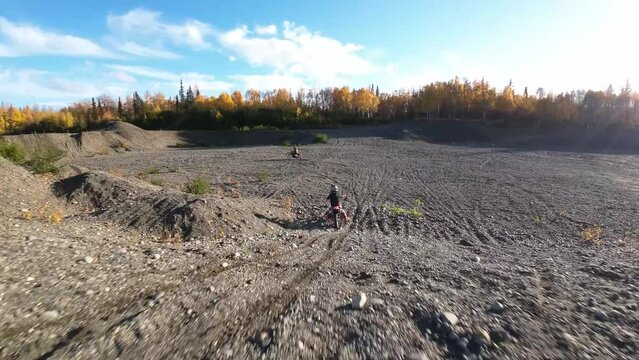 Two brothers riding dirt bikes with FVP drone