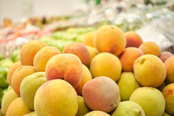Stack of peaches in a fruit store. Bright image with copy space.