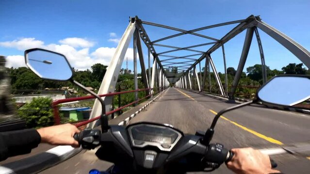POV motorbike ride through bridge over river