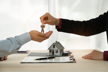 Businessman, insurance sales agent handing over house and car keys to customer in trading or...