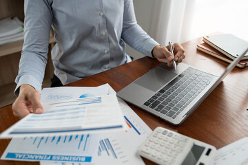 Businesswoman, accountant working on laptop computer in office Make accounting analysis report, real estate investment information, finance and tax system concept.