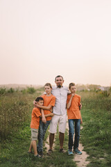 Happy Fathers day. Father with son are walking in the field. Dad hugs boy. The concept of Fathers day, relationships with children, care and love.