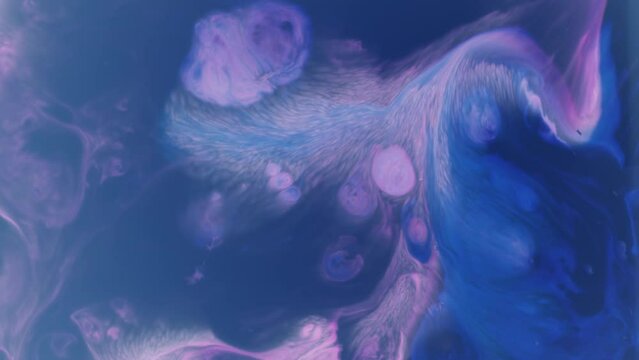 Top shot of blue with purple and some pink psychedelic paint colors moving on a water surface creating a living abstract background.