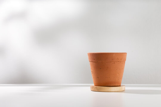 Clay pot on white wooden table.