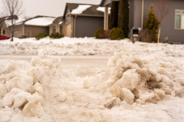 Snowbank at the end of a driveway left after city snowplows cleared a street.