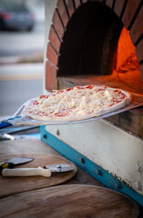 Placing pizza into brick oven