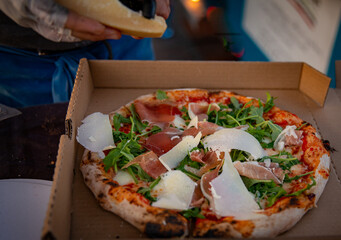 Carving fresh parmesan on a pizza