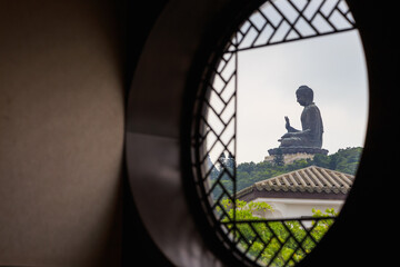 Tian Tan largest bronze Buddha viewed from window of a restaurant in Ngong Ping village.