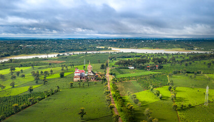 Naklejka premium Aerial view of an ancient pagoda in the middle of a green tea field in Pleiku town, Gia Lai province, Vietnam
