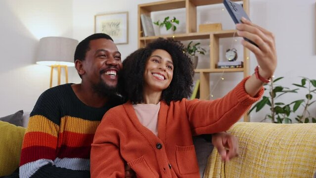 Selfie love, home couch and couple with happiness and smile together for mobile web photo. Social media, profile picture and living room sofa of young people sitting in the lounge feeling happy