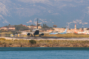 Fototapeta na wymiar View of modern passenger plane aircraft on an runway airfield ready to take off, airstrip with commercial airplane before take off or after landing, airliner with mountains in a summer day
