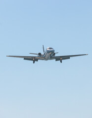 View of modern private reactive plane aircraft in flight, business airliner jet airplane before in the air with mountains in the background in a summer sunny day, corporate jet view