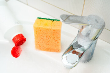 Cleaning plumbing with cleaning products, glove sponge and plumbing.