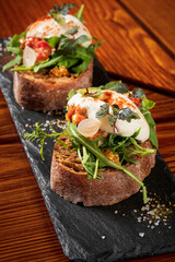 Italian bruschetta with roasted tomatoes, mozzarella cheese and herbs