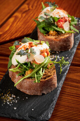 Italian bruschetta with roasted tomatoes, mozzarella cheese and herbs