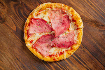 pizza with ham on the wooden background