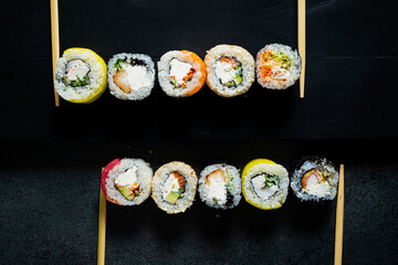 sushi with chopsticks on the black background