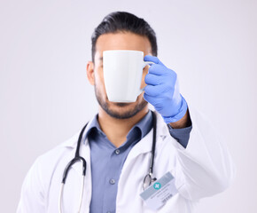 Hand, coffee and break with doctor man in studio on a gray background for a drink to start his...