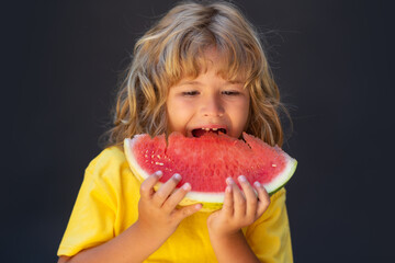Kid face and watermelon, close up. Cute child eat watermelon. Kid is picking watermelon on gray background.