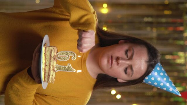 Beautiful happy young woman wearing sweater holding birthday cake number 61 golden candles burning by lighter. Concept of celebrating birthday and anniversary. POV.