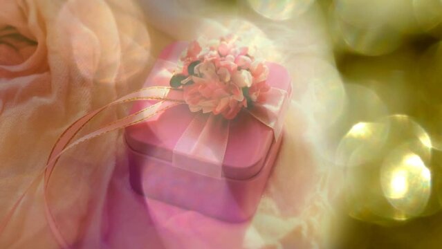 A pink gift box and sniny  golden bokeh. Wedding, Birthday. Luxury ceremony