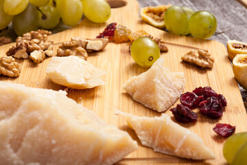 Healthy food. Differet type of cheese with grape and nuts on wooden background. Gourmet delicatessen