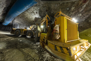Mining load truck being filled with ore by an excavator underground in a mine site in Australia