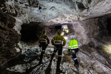 Miners underground inspecting work in progress at a mine site in Australia - obrazy, fototapety, plakaty