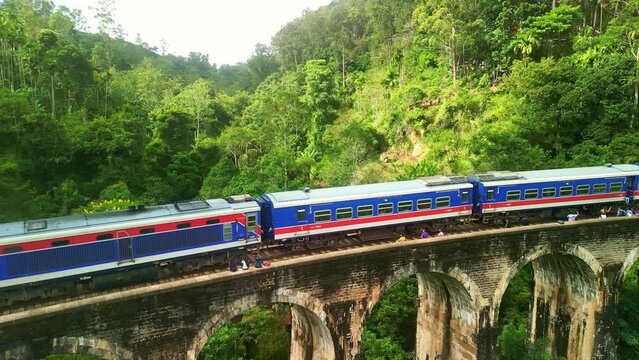 Drone Sri Lanka 4k. Kandy to Ella train on Nine Arch bridge in Sri Lanka. Scenic railway route in tea plantations. South Asia summer tourism.