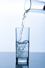 drinking water pouring into glass on white background