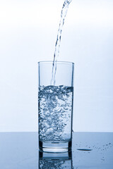 drinking water pouring into glass on white background