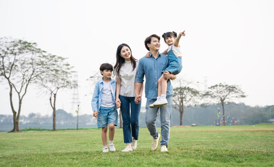 Fototapeta premium Asian family photo walking together in the park