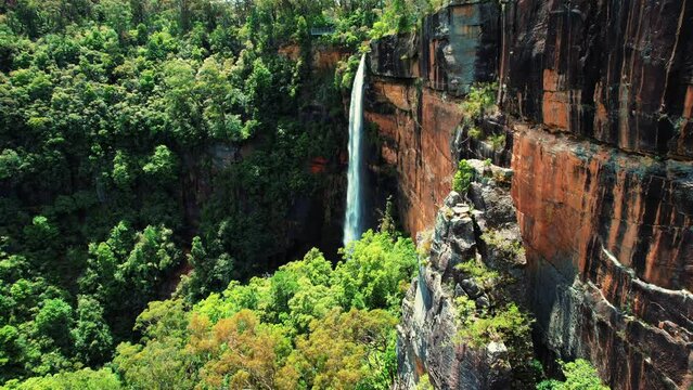Fitzroy Falls, Australia, Aerial Drone Flys along Cliff Face Towards Falls
