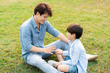 image of an asian father and son having fun in the park