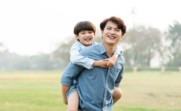 image of an asian father and son having fun in the park