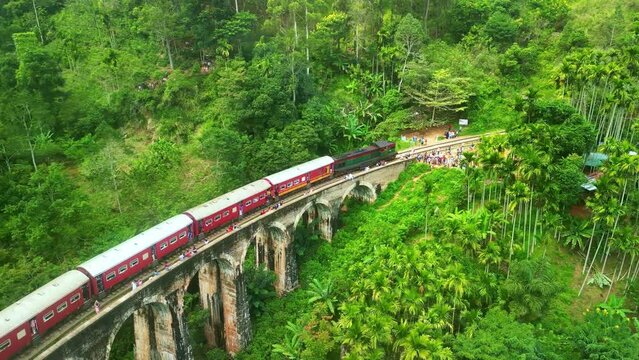 Aerial drone 4k. Scenic train on Nine Arch Bridge. Kandy to Ella railway. South Asia summer tourism.