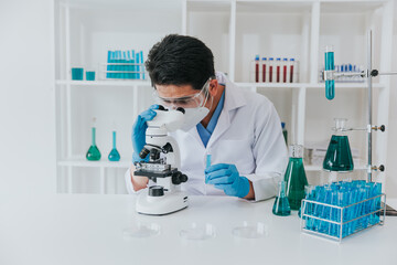 Young scientist looking through a microscope in a laboratory. Young scientist doing some research.