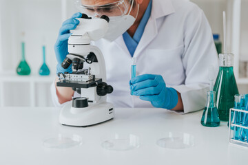 Young scientist looking through a microscope in a laboratory. Young scientist doing some research.