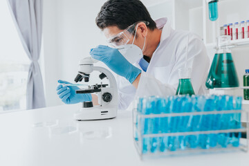 Young scientist looking through a microscope in a laboratory. Young scientist doing some research.