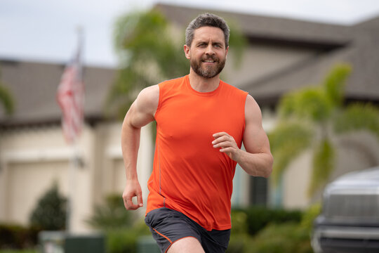 Sport runner. Man running. Fit male sport fitness model sprinting outdoors. Attractive man running fast, workout outdoors, runner jogging over american street. - Powered by Adobe