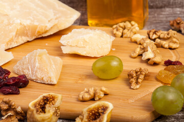 Cheese, honey and grape on wooden background in studio photo