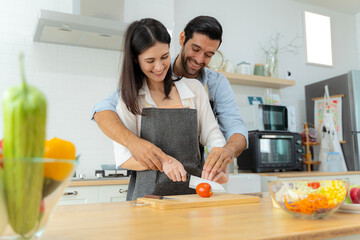 Young couple having fun while preparing breakfast together on a beautiful morning, cooking...