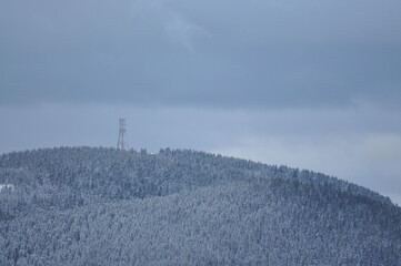 Fototapeta premium Aerial view of a steel tower on the snowy Brocken in the Harz mountains in Germany